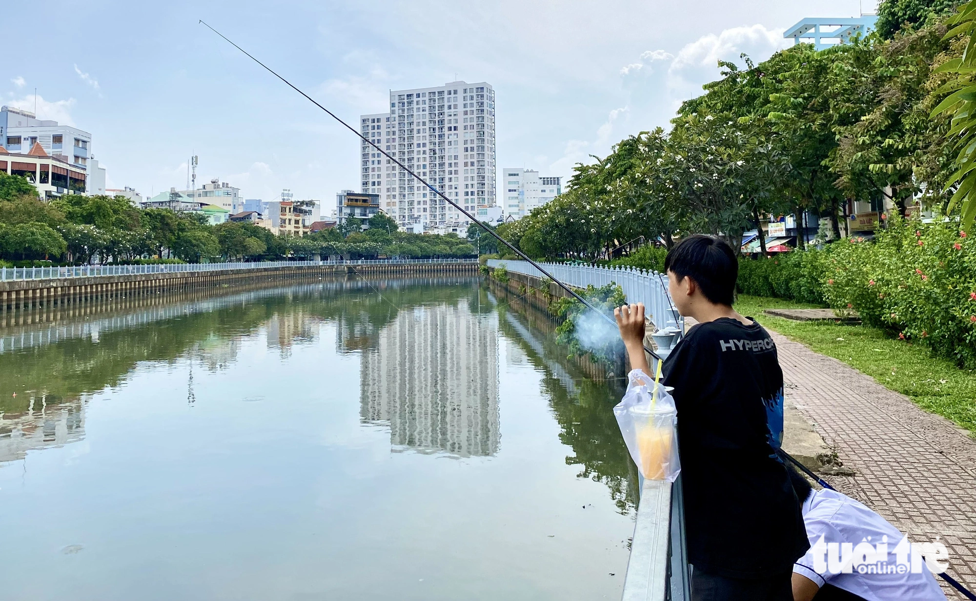 Many people park their vehicles to fish on the canal regardless of prohibition signs. Photo: Tien Quoc / Tuoi Tre