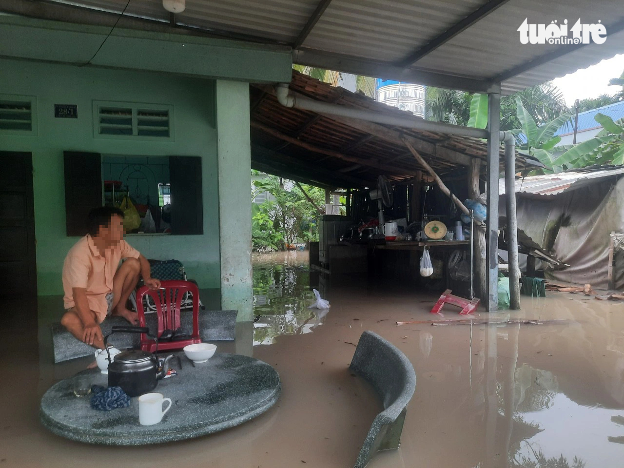 A local man sits on a stone bench in his flood-hit house in Binh Duong Province, southern Vietnam, October 16, 2023. Photo: T.D / Tuoi Tre