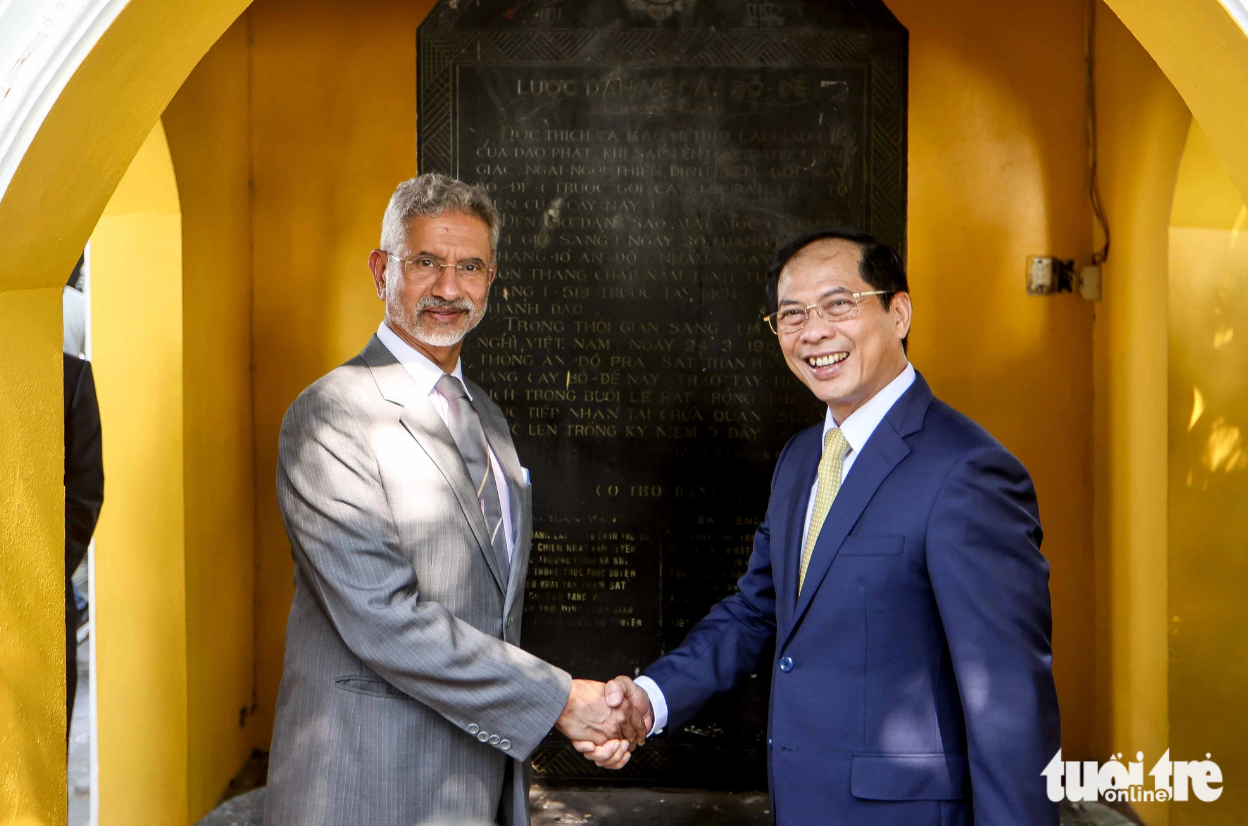 Foreign Minister Son (R) shakes hands with his Indian counterpart Jaishankar in front of a stone slab describing the Bodhi tree at Tran Quoc Pagoda. Photo: Nguyen Khanh / Tuoi Tre