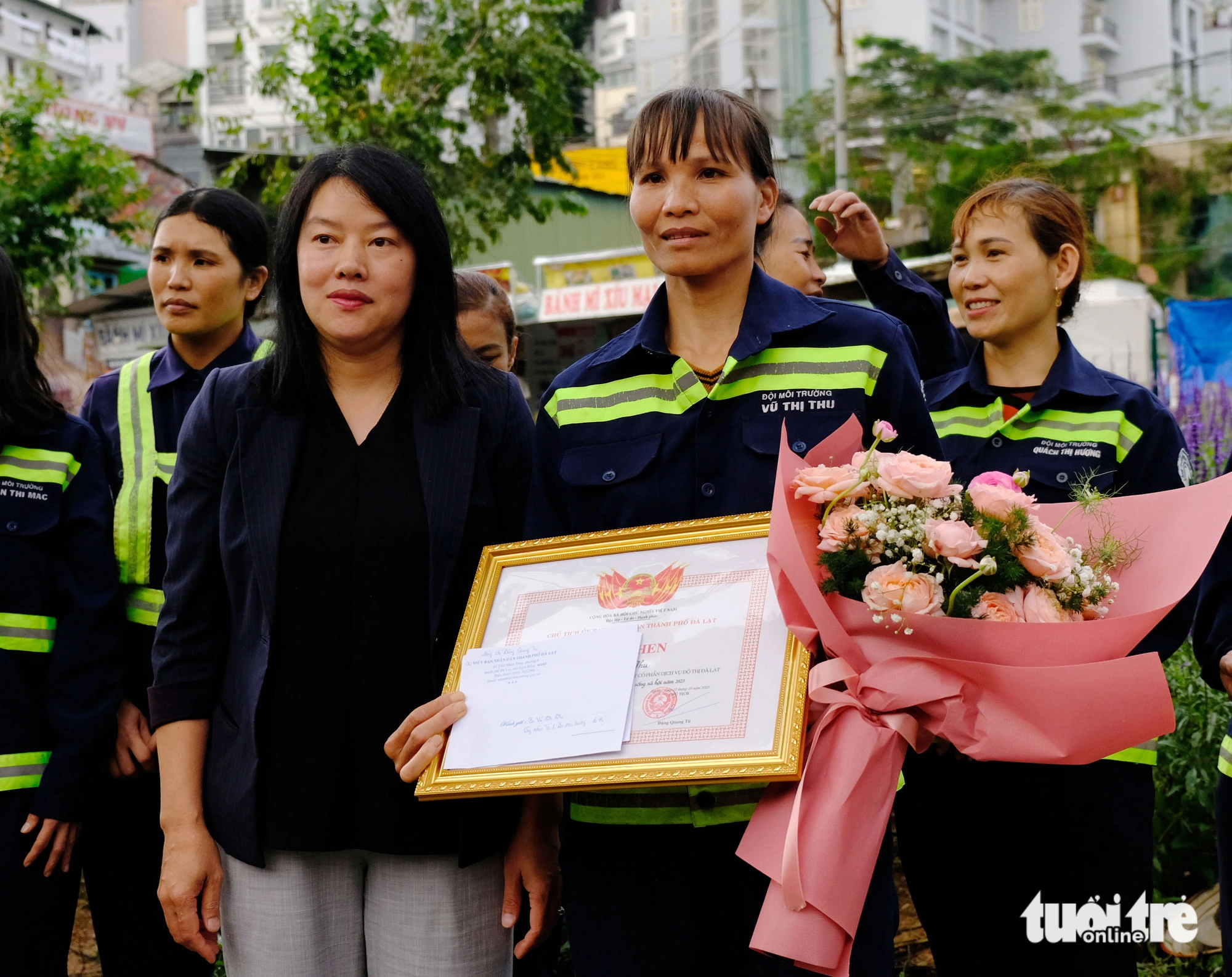 Tran Thi Vu Loan (L), deputy chairwoman of the Da Lat City People’s Committee in Lam Dong Province, Vietnam's Central Highland region, awards Vu Thi Thu with a certification of commendation, October 16, 2023. Photo: M.V / Tuoi Tre