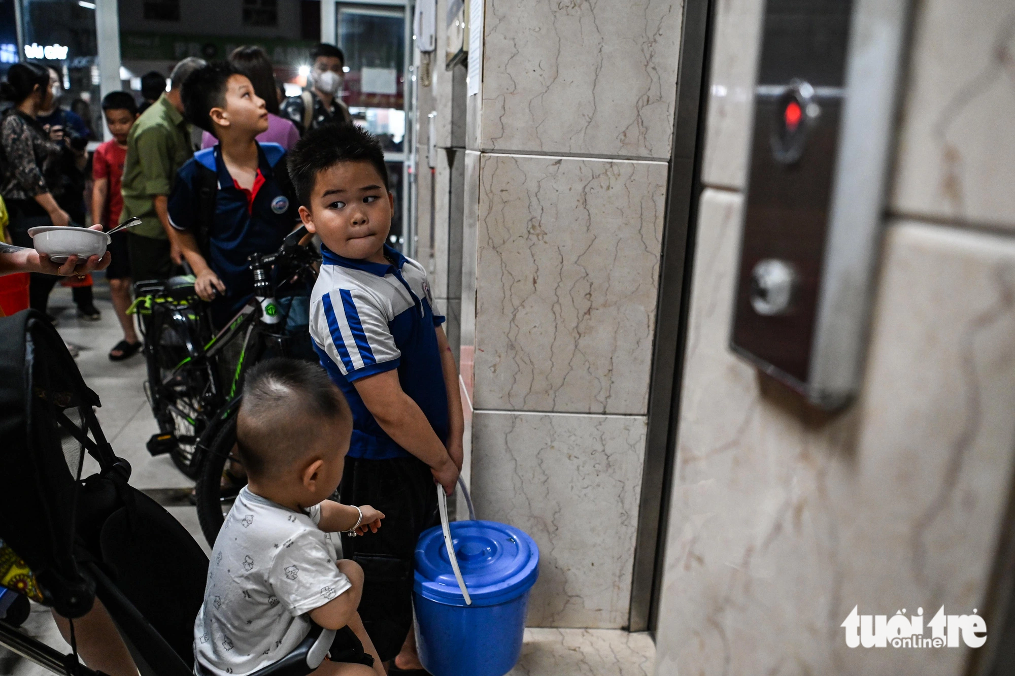 Children help their family fetch water at Thanh Ha urban area in Thanh Oai District, Hanoi, October 17, 2023. Photo: Hong Quang / Tuoi Tre