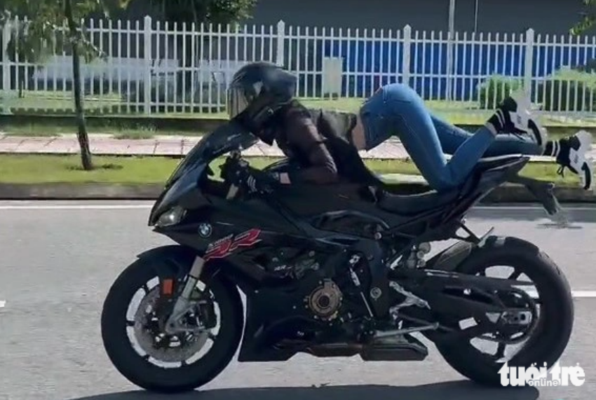 A screenshot captured from a video shows Ngoc Trinh lying down on a motorcycle