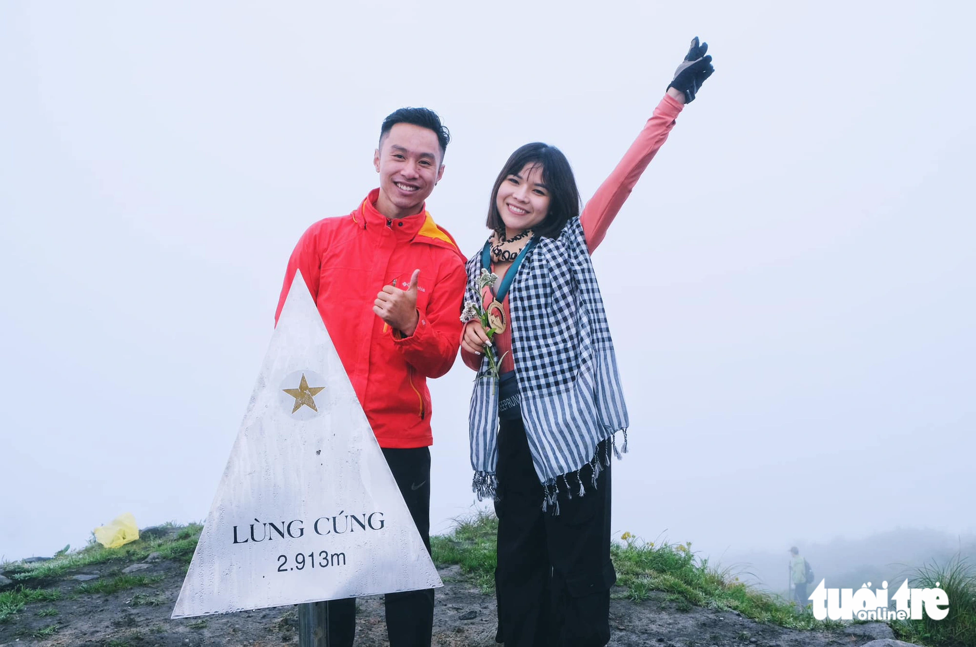 Tourists take a photo on the peak of Lung Cung Mountain. Although they fail to hunt clouds, they experience the imposing forests, mountain and waterfalls. Photo: Hong Quang / Tuoi Tre