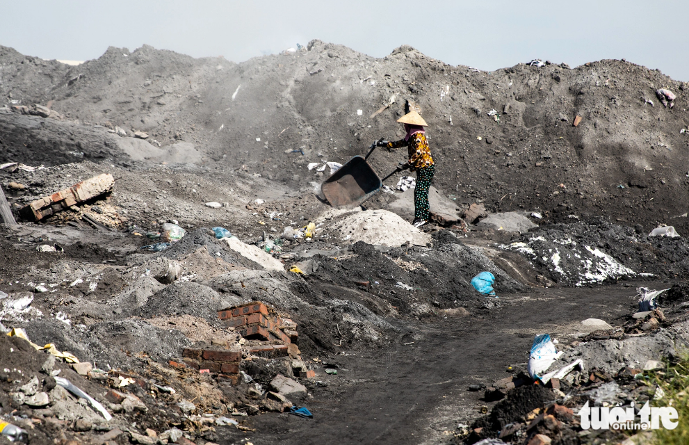 A woman discharges waste into the environment in the Man Xa aluminum recycling village in Bac Ninh Province, northern Vietnam. Photo: Tuoi Tre