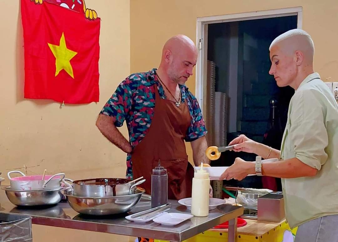 Andrei Abramov (L) and Valeriia Kuropatkina (R), owners of Donut Nga, prepare donuts for customers. Photo: Minh Chau / Tuoi Tre News