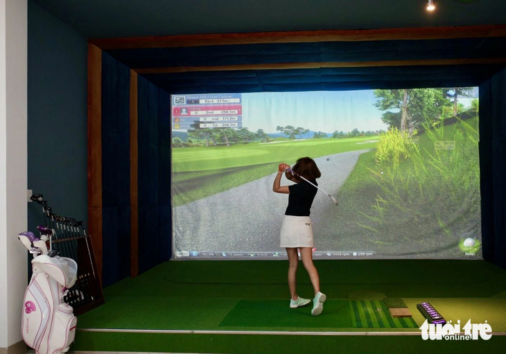 A tourist experiences indoor 3D golf services. Photo: Thanh Chuong / Tuoi Tre